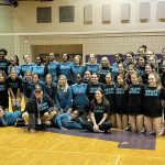 The Woodlawn High and St. Joseph's volleyball teams take a picture together in their coordinated black-and-teal shirts and jerseys in support of coach Maria Gonzalez.